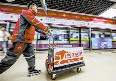 图为快递员搭乘地铁运送货物